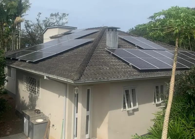 Casa com telhado de quatro águas coberto de módulos